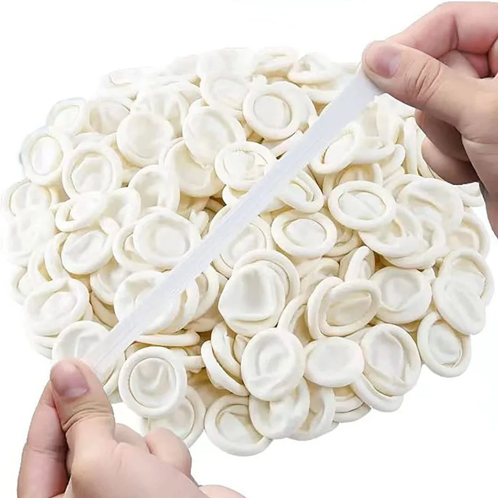 Lot de doigtiers jetables en latex blancs, empilés dans un emballage transparent, parfaits pour une protection hygiénique.