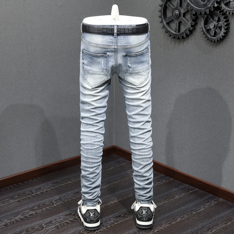 The latest designer's fashionable new men's jeans are washed, elastic, slim fit, light blue slit jeans, high street trendy hip-h