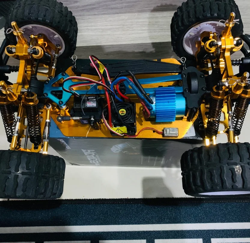 La voiture télécommandée 4WD 2.4GHz tout terrain bleue en action, soulevant un peu de poussière sur un chemin de terre.