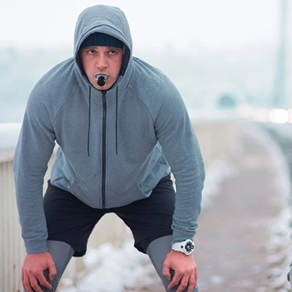 Person using a Portable Breathing Fitness Exerciser outdoors, demonstrating how to enhance lung capacity with adjustable settings.