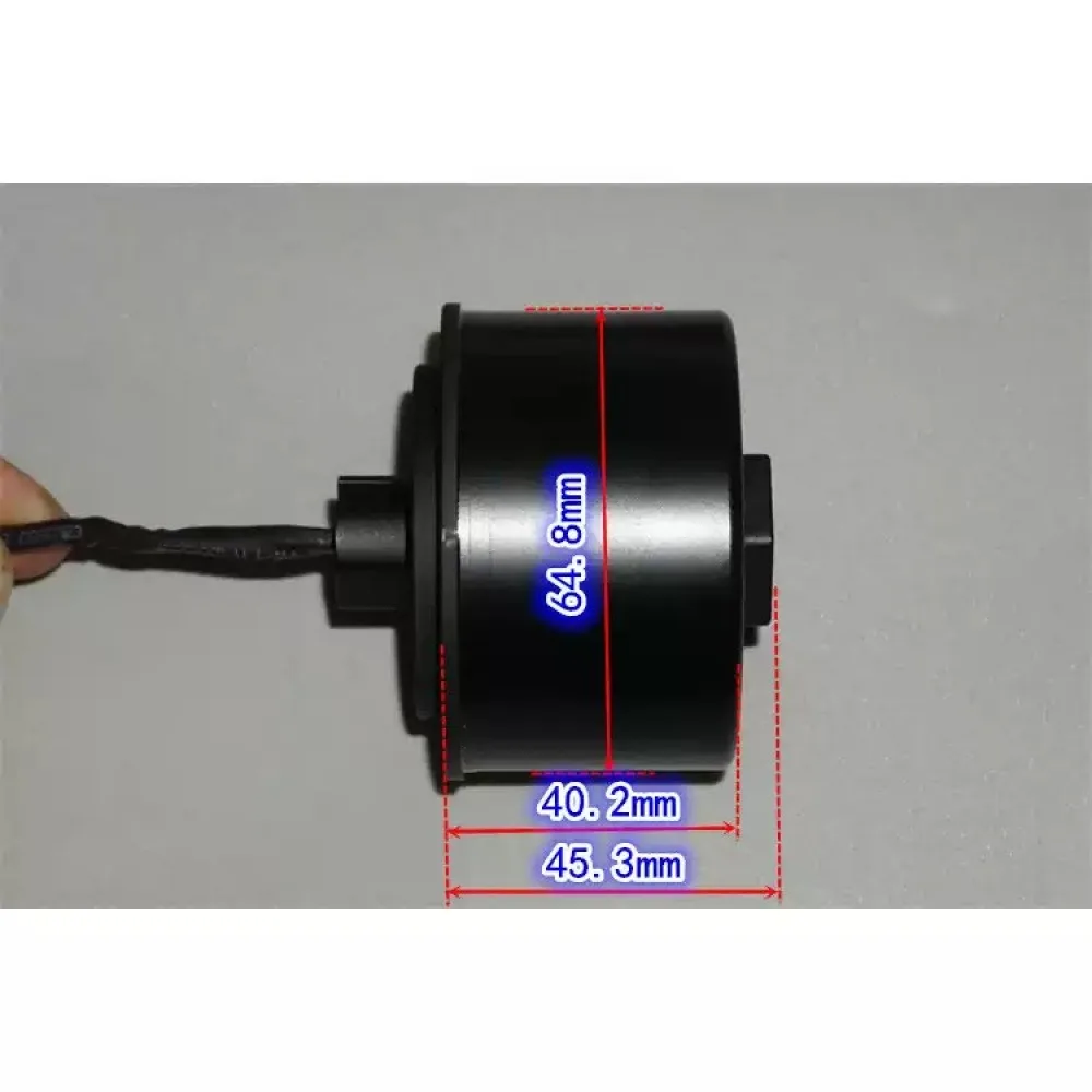 Servomoteur brushless 24V posé sur une surface de travail, câble et connecteur apparents.
