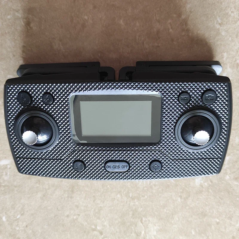 Télécommande SG908 MAX tenue en main, montrant les molettes et boutons.