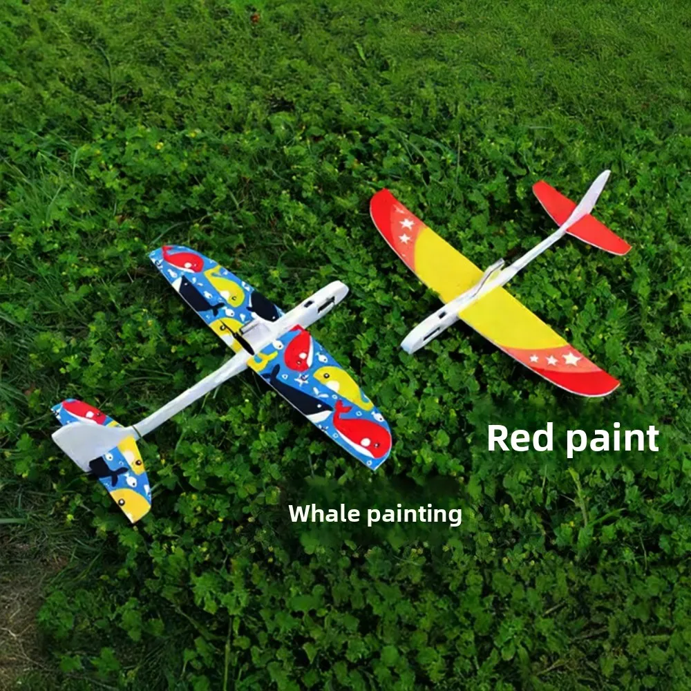 Enfant peignant son avion RC en mousse EPP, kit DIY planeur jouet volant, avec des pinceaux et de la peinture.