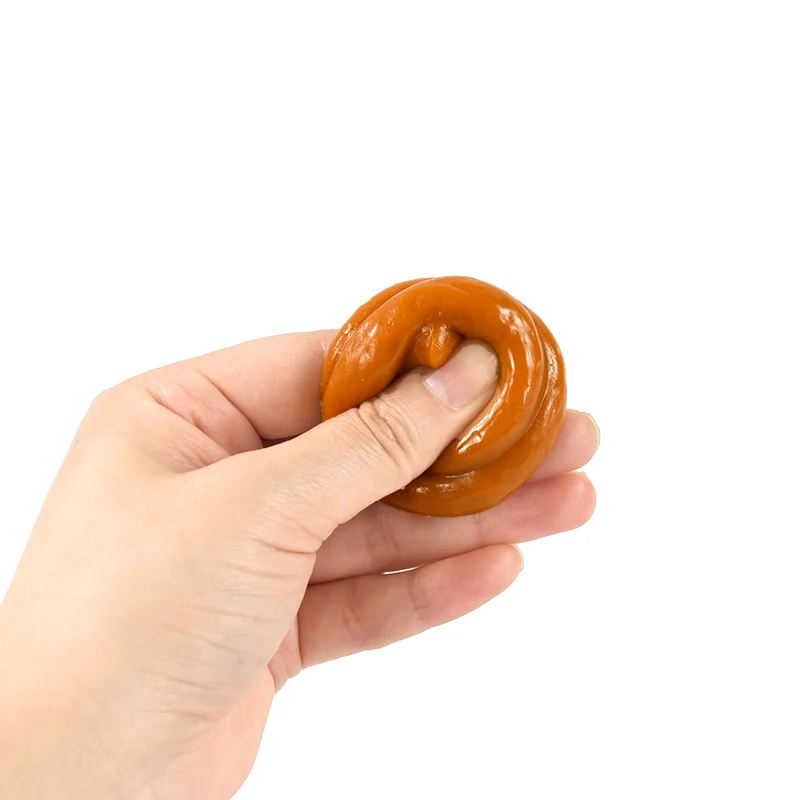 fejkad bajs leksak hålls i handen för storleksreferens