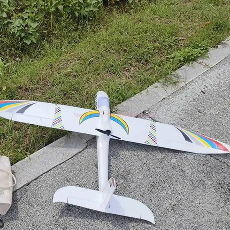 Planeur RC 1.2m en vol, ciel bleu en arrière-plan, capturé en pleine action.