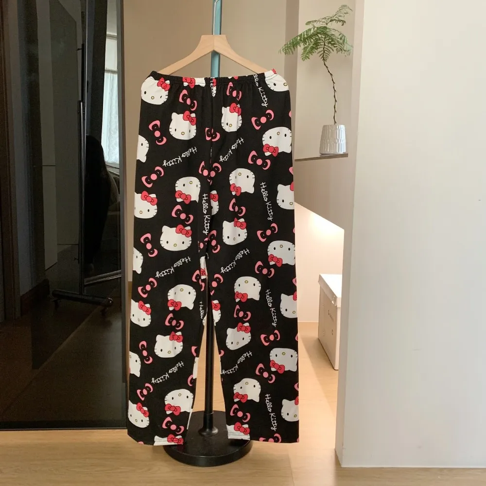 A pair of loose-fitting Hello Kitty pajama pants with a charming cartoon print black