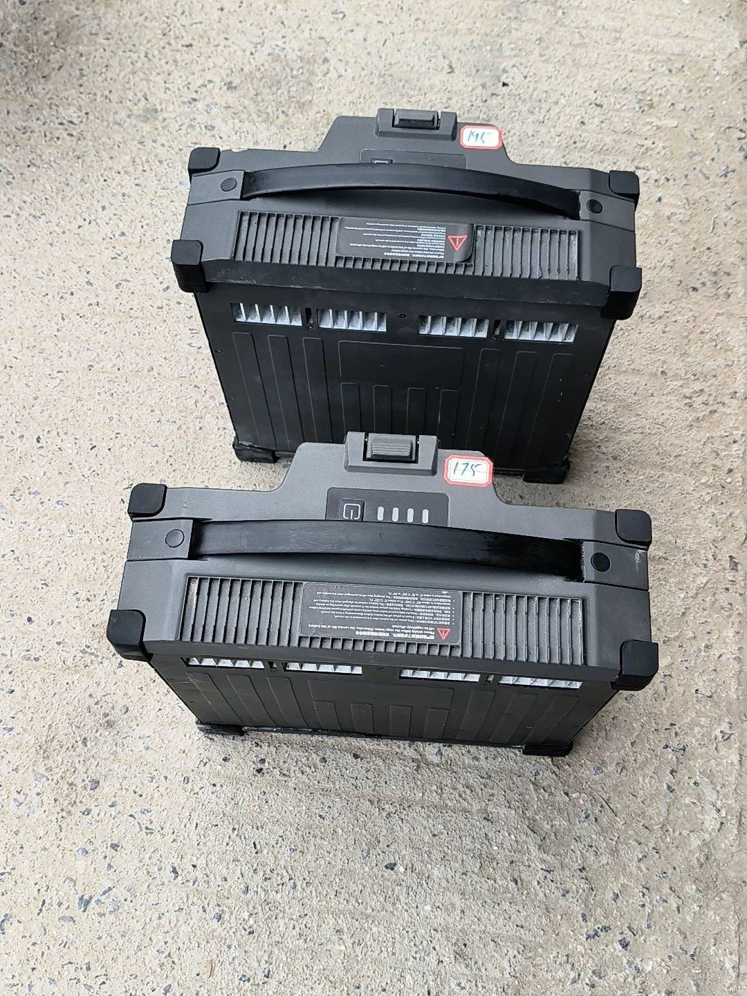 Deux batteries drone gris foncé côte à côte, illustrant leur format compact et leur design robuste.