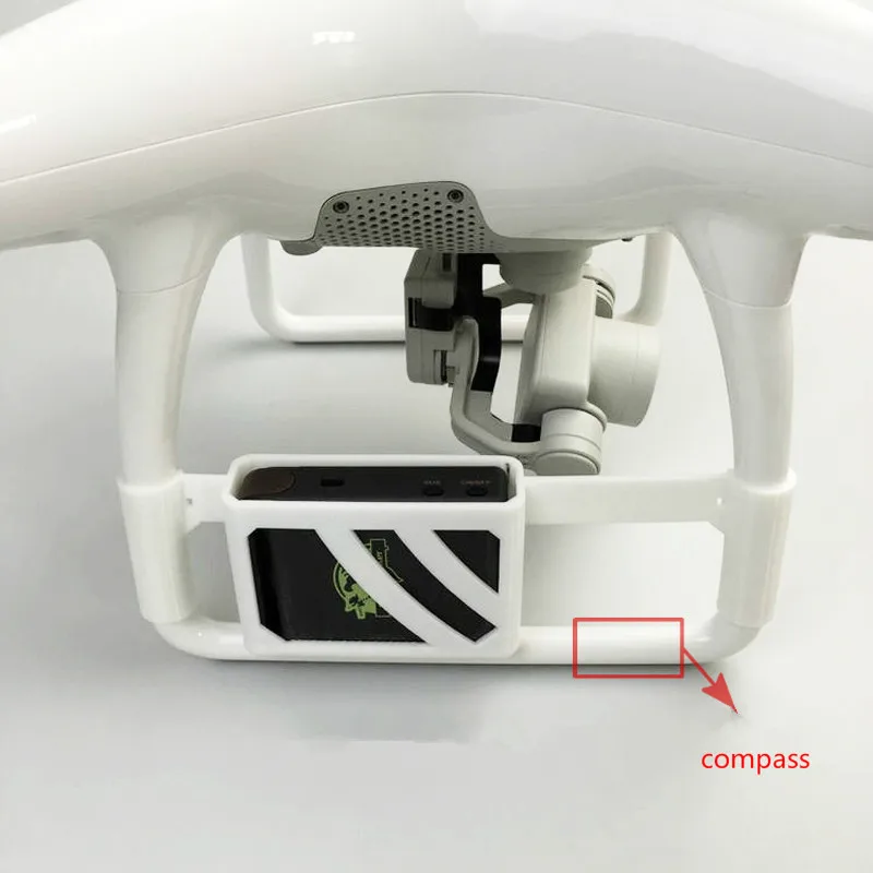 Support de fixation pour traceur GPS TK102 posé sur une surface, avec le drone Phantom 4 en arrière-plan flou.