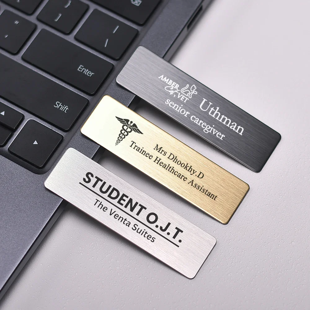 Targhetta identificativa in acciaio inox argento esposta su un tavolo