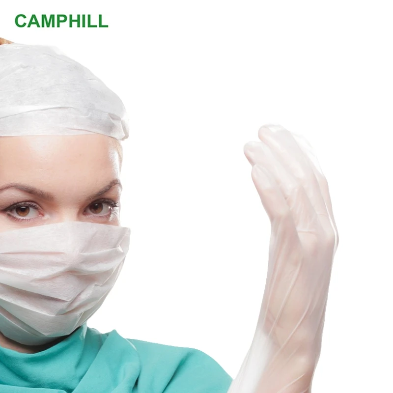 Mains portant des gants jetables PVC transparents en situation d'utilisation.