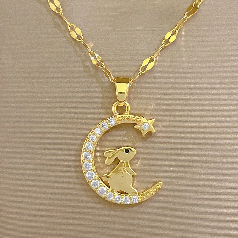 un pendentif de collier doré motif lapin et lune sur une boite de bijoux 