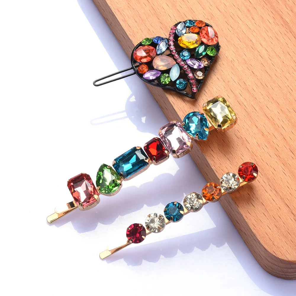 Colorful gemstone hair pins on a wooden surface