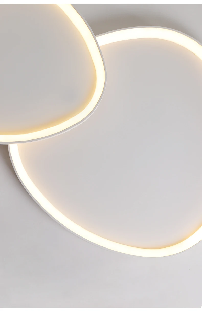 The Nordic Minimalist Ceiling Light features two overlapping round lights that emit a soft white glow on a gray background, with dimmable brightness to create the perfect ambiance.