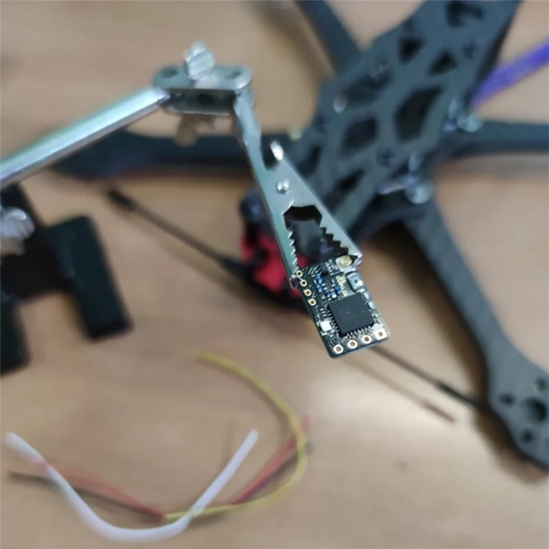 Récepteur radio ELRS 2.4G pour drone FPV, installé sur une carte de vol avec câbles de liaison.