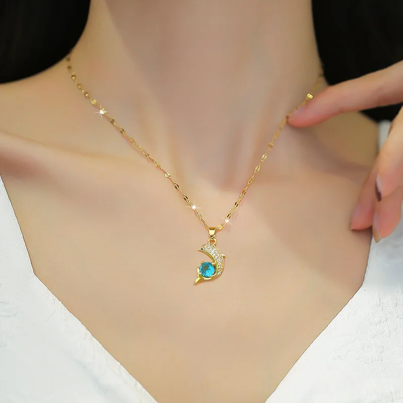 une femme qui porte un collier doré avec pendentif dauphin 