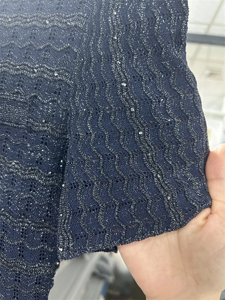 فستان كحلي طويل بتفاصيل لامعة وأكمام واسعة