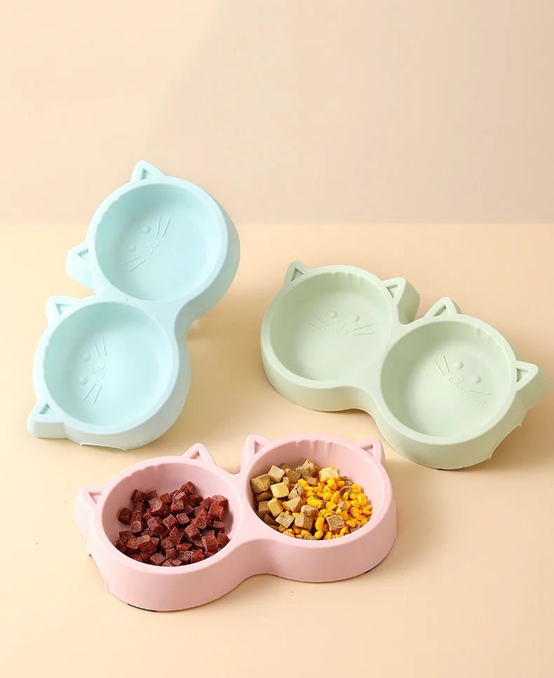 Double pet feeding bowl with cat face design in various colors.