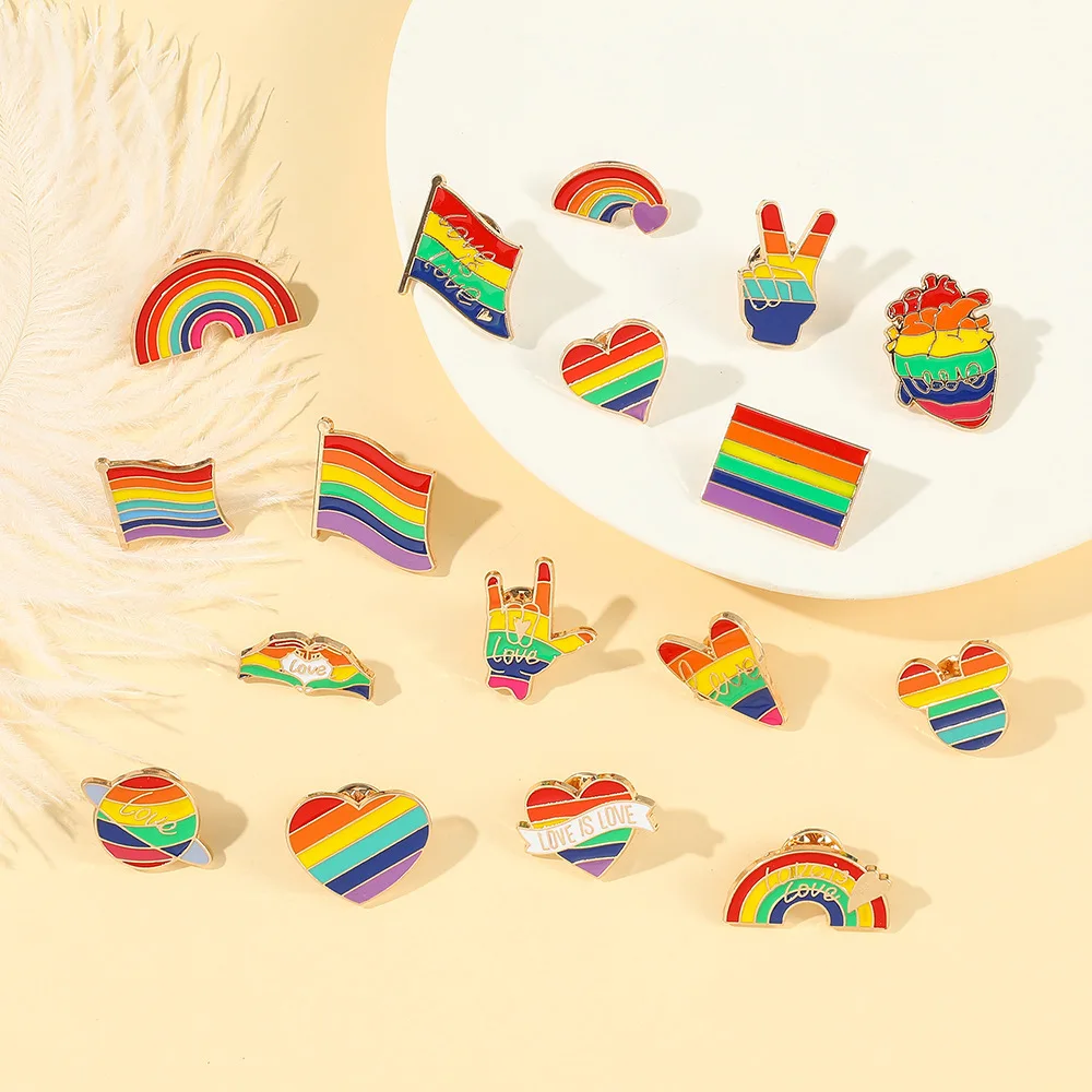 Collection of rainbow-themed pins on a beige background