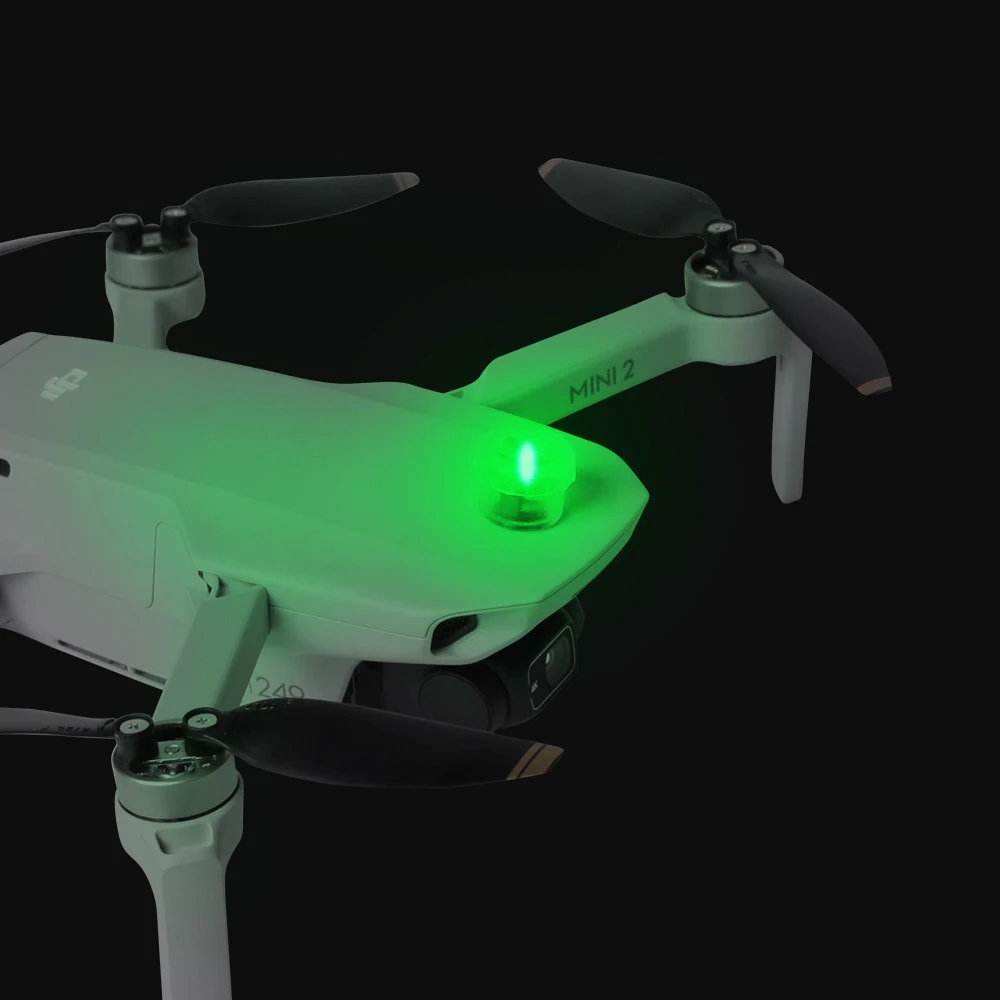 Lampe stroboscopique universelle pour drone attachée à un Mavic Mini 3 Pro, illuminant le ciel nocturne.