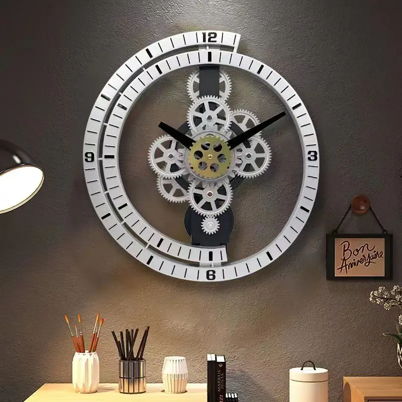 An Industrial Gear Wall Clock is mounted on a gray wall, capturing a modern industrial aesthetic with its exposed gears. Below, a desk is organized with pencils, a lamp, and books. A framed "Bon Appétit" sign complements the setting nearby.