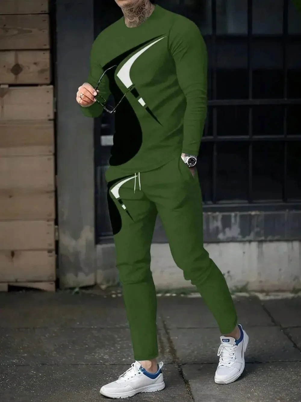 Man wearing striped patchwork long sleeve top and pants set in a sunny outdoor setting green