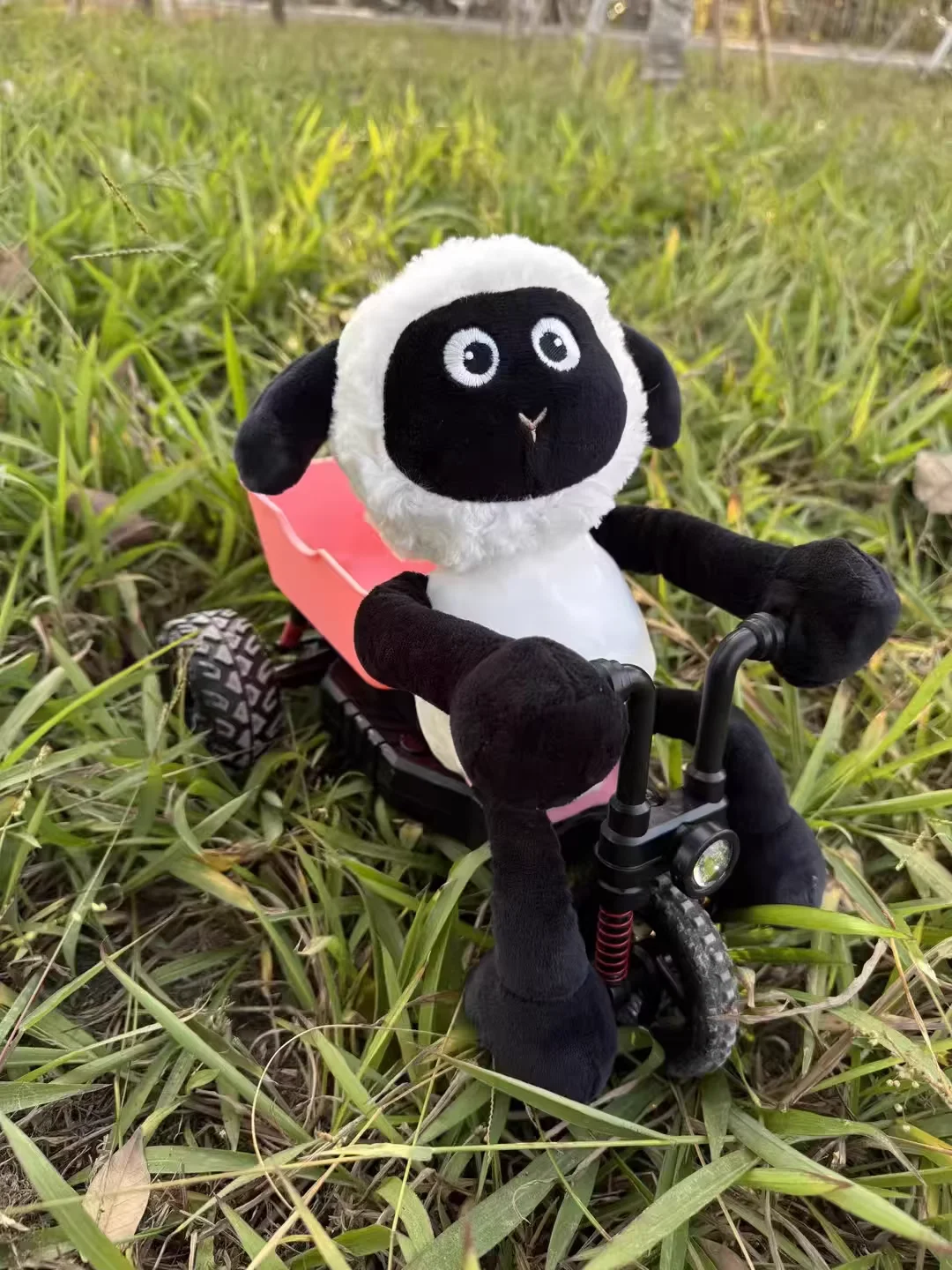 Gros plan sur la voiture RC Lamb Tricycle drift montrant ses roues larges et son design rose/vert.