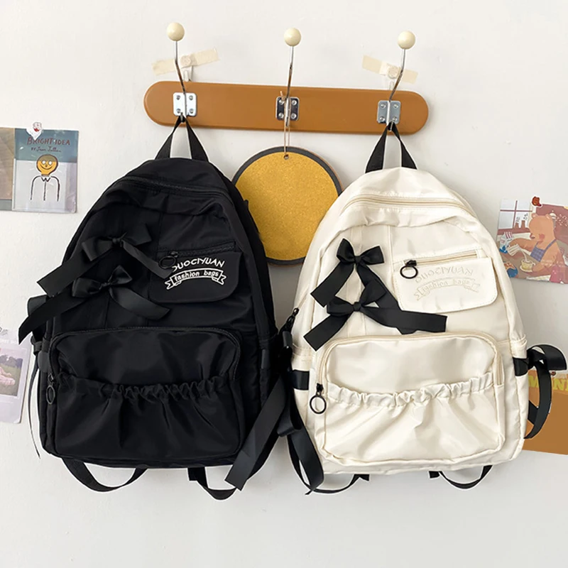 Stylish kawaii backpack with bowknot detail, designed for women and girls, featuring soft pastel tones and spacious compartments for school essentials. black and white