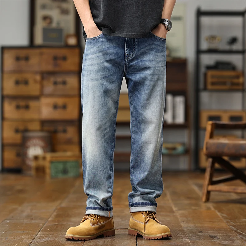 Jeans en denim bleu avec un effet délavé et des bas de manche retroussés, présentant une coupe ample à jambe large.