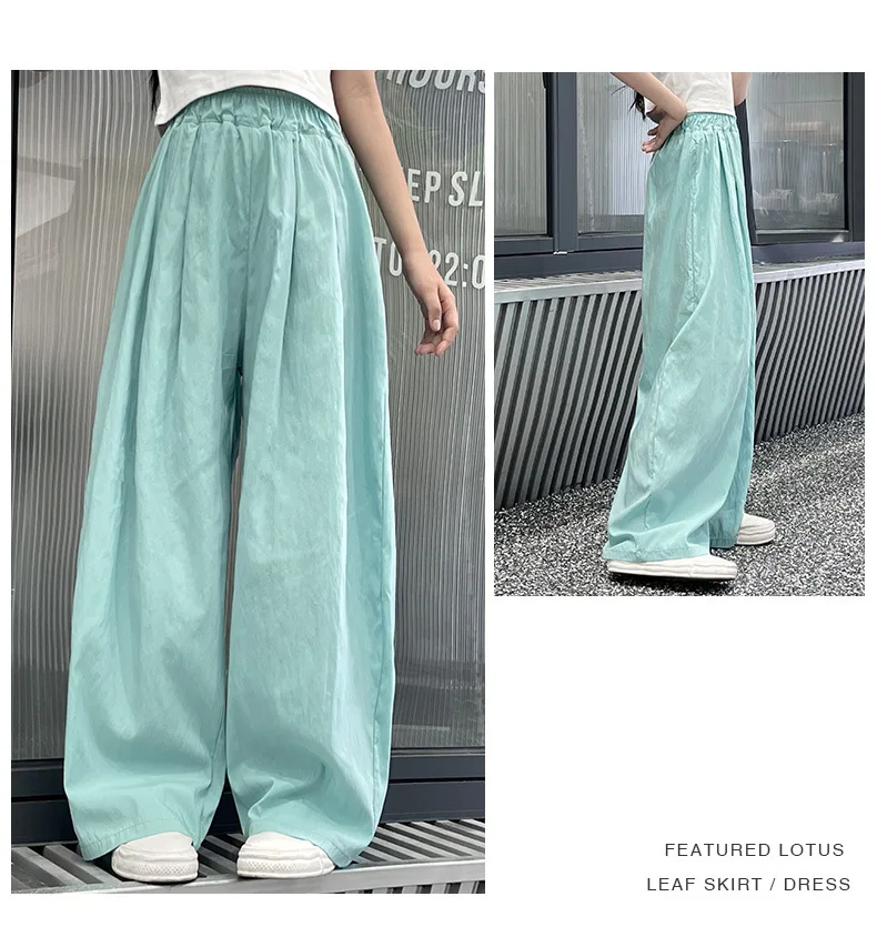 Teen girls’ casual summer wide-leg pants in lightweight fabric, styled with sandals and a simple tee on a beach boardwalk backdrop green