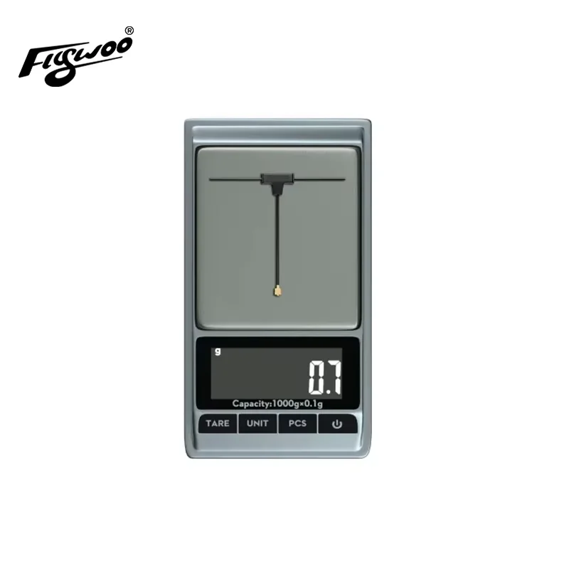 Antenne Flywoo ELRS 2.4GHz U.FL de 10cm, comparée à une pièce de monnaie pour illustrer sa légèreté et compacité.