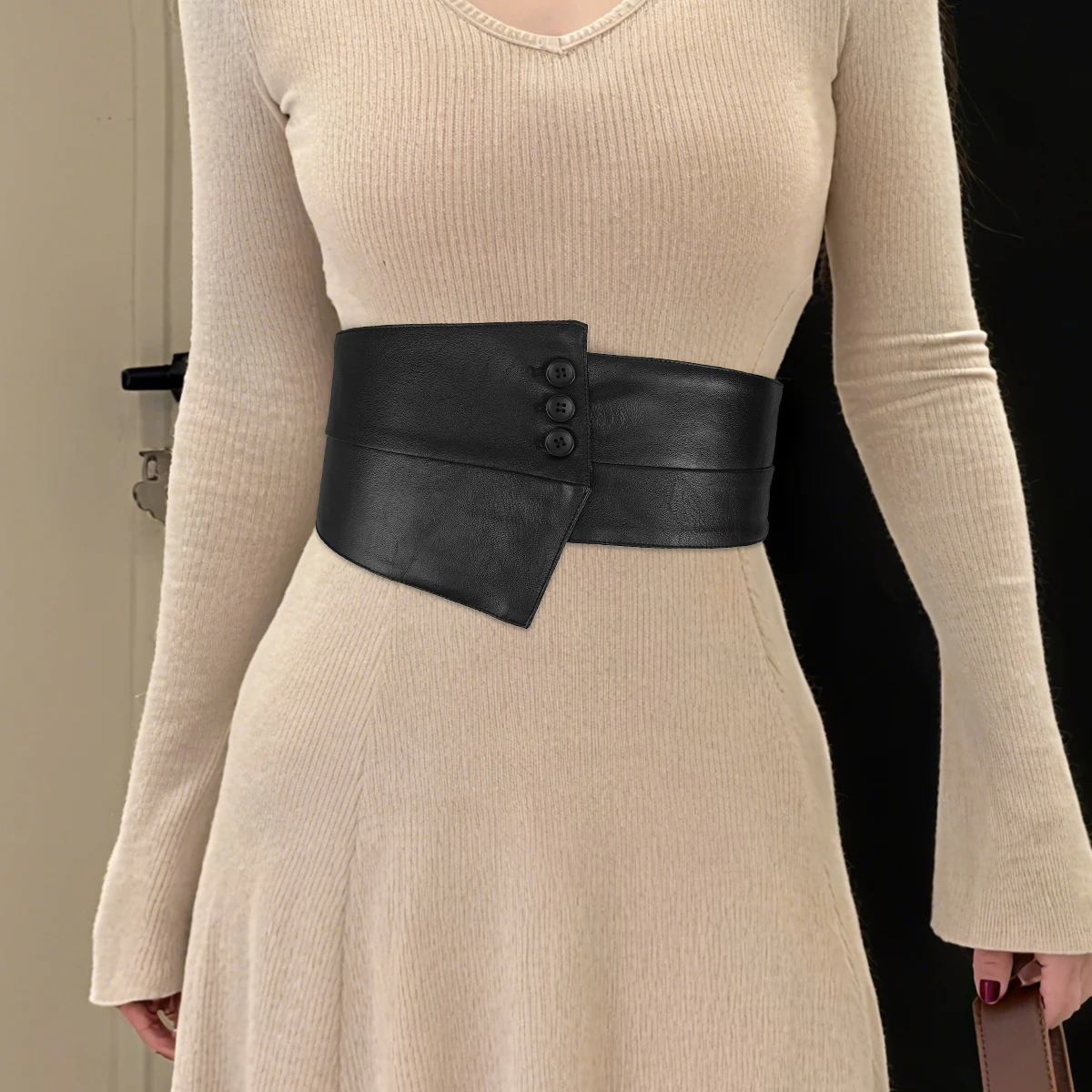 Ein schwarzes Damenmode-Kleid mit breitem Gürtel, verziert mit unregelmäßigem Design aus PU-Lederbund und elastischem Korsett