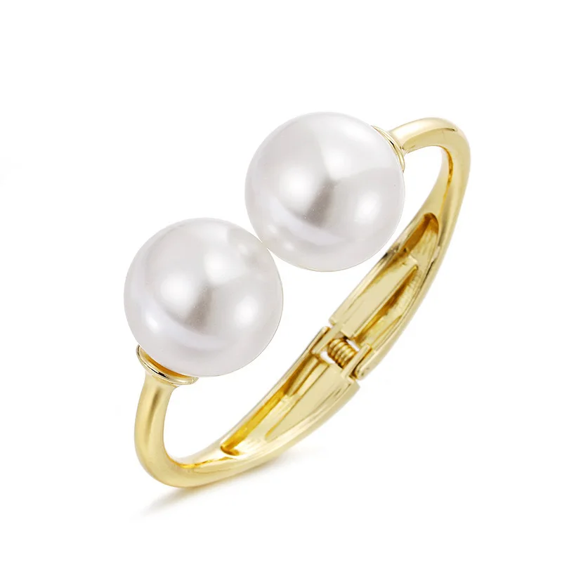 Gold-tone cuff bracelet with pearl ends for women – wide statement bangle with modern fashion appeal.