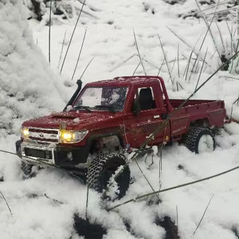 Dessous du véhicule RC MN82 révélant la transmission 4WD et les amortisseurs.