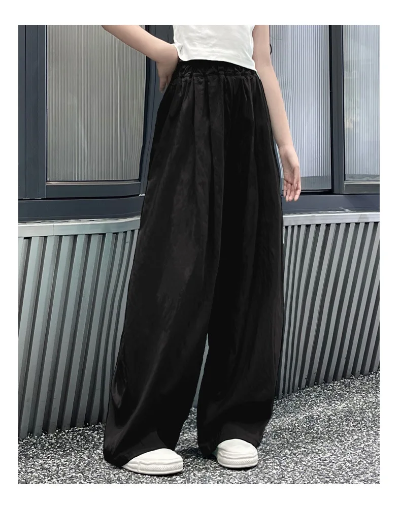 Teen girls’ casual summer wide-leg pants in lightweight fabric, styled with sandals and a simple tee on a beach boardwalk backdrop black 2