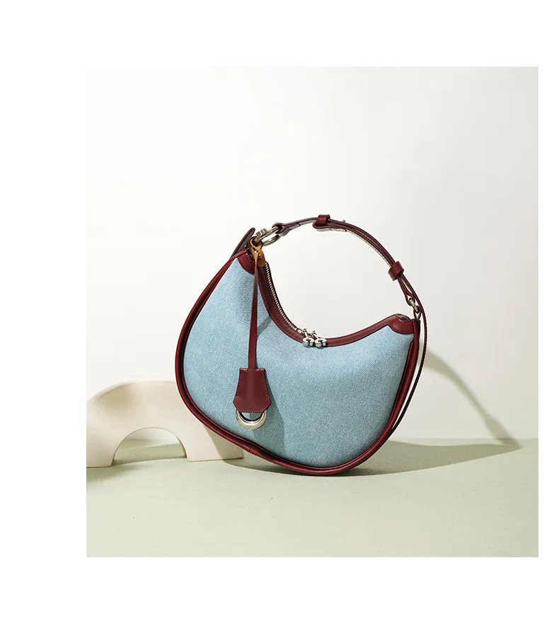Half moon shoulder bag made of denim with genuine leather trim – casual and stylish design for daily use.