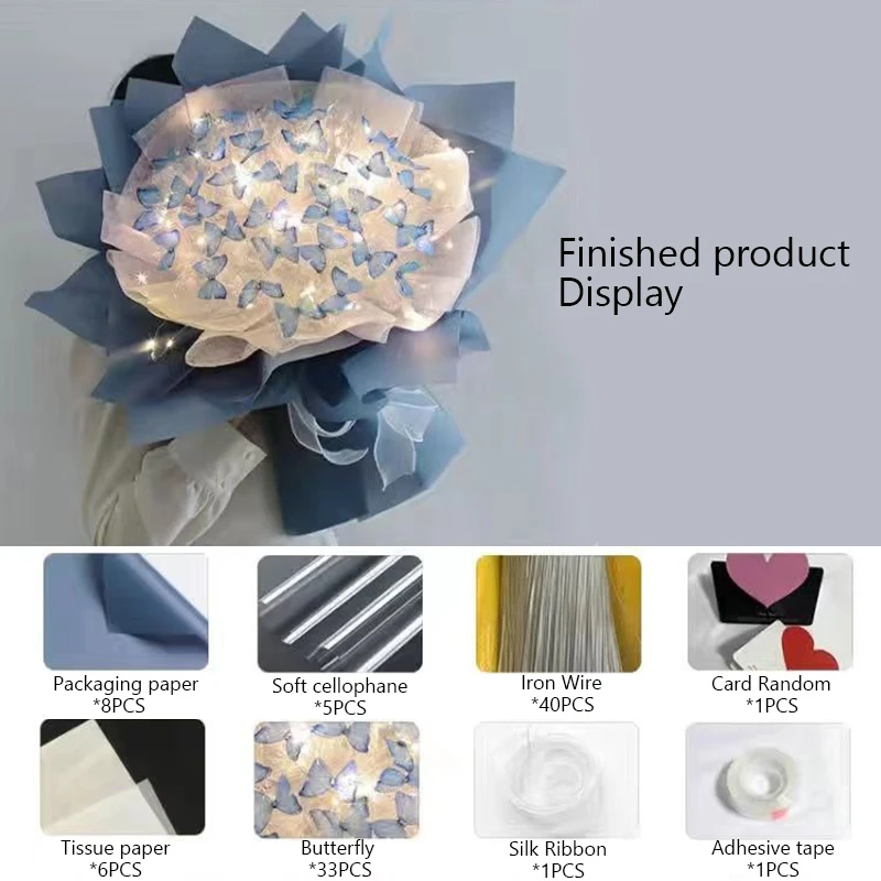 A Creative Handmade Butterfly Bouquet Material Bag, perfectly designed with blue and cream packaging. The bouquet is embellished with small butterfly designs and enclosed in soft cellophane. Displayed are the materials used to craft this delightful home decoration: artificial flowers, iron wire, ribbon, adhesive tape, and tissue paper. Text: "Finished product Display.