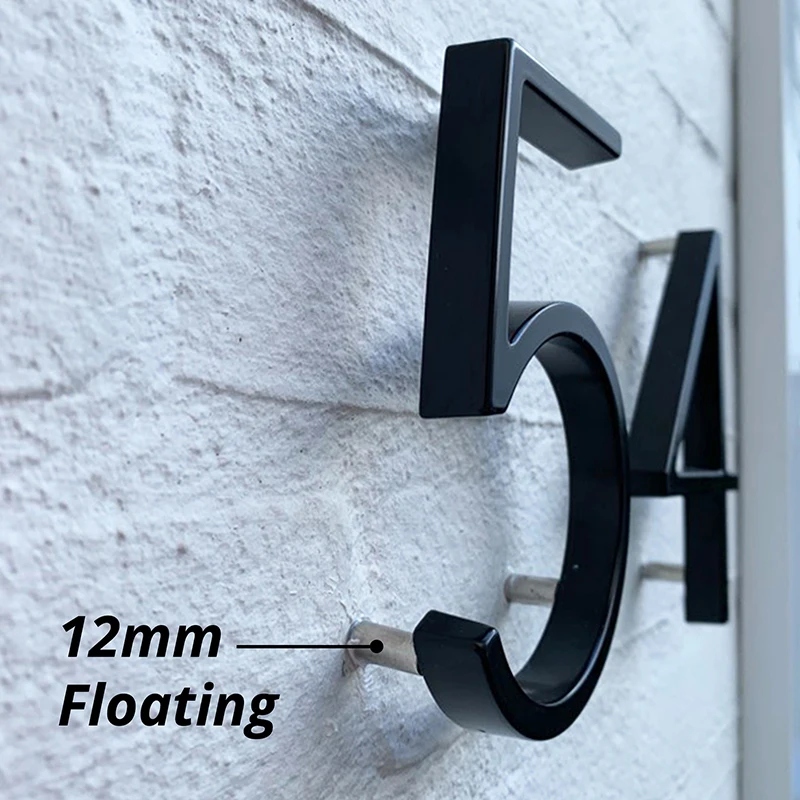 Person installing floating house number with included screws