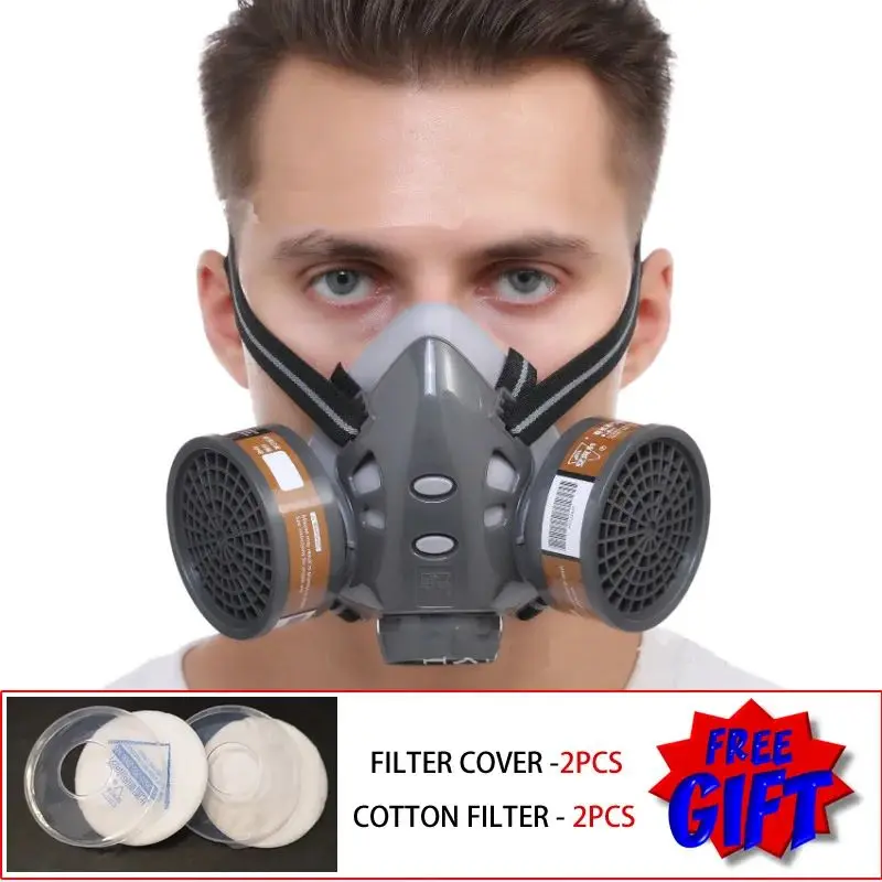 Demi-masque respirateur anti-poussière double filtres posé sur une table, idéal pour peinture et vapeurs organiques.