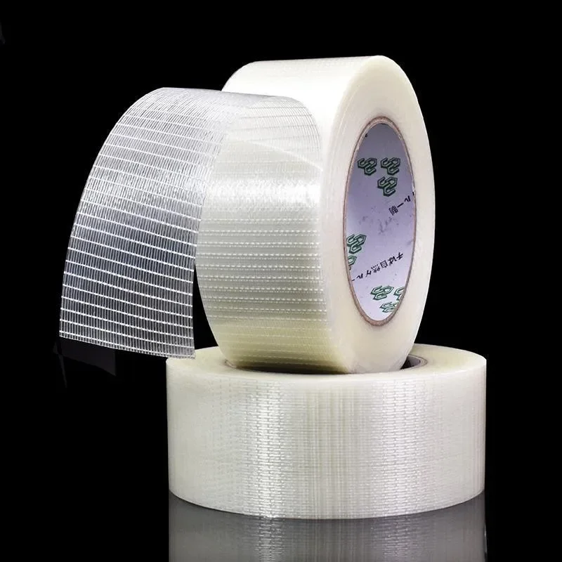 Main déroulant le ruban adhésif double face 25 mètres, parfait pour fixer des pièces de modélisme.