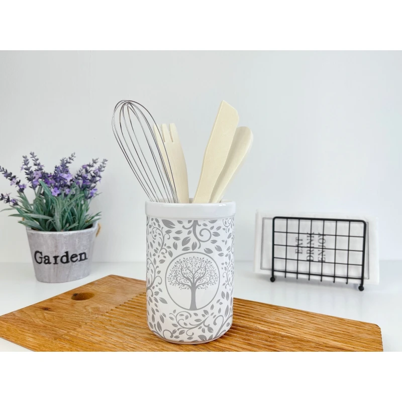 White ceramic utensils and kitchen utensils on a wooden countertop