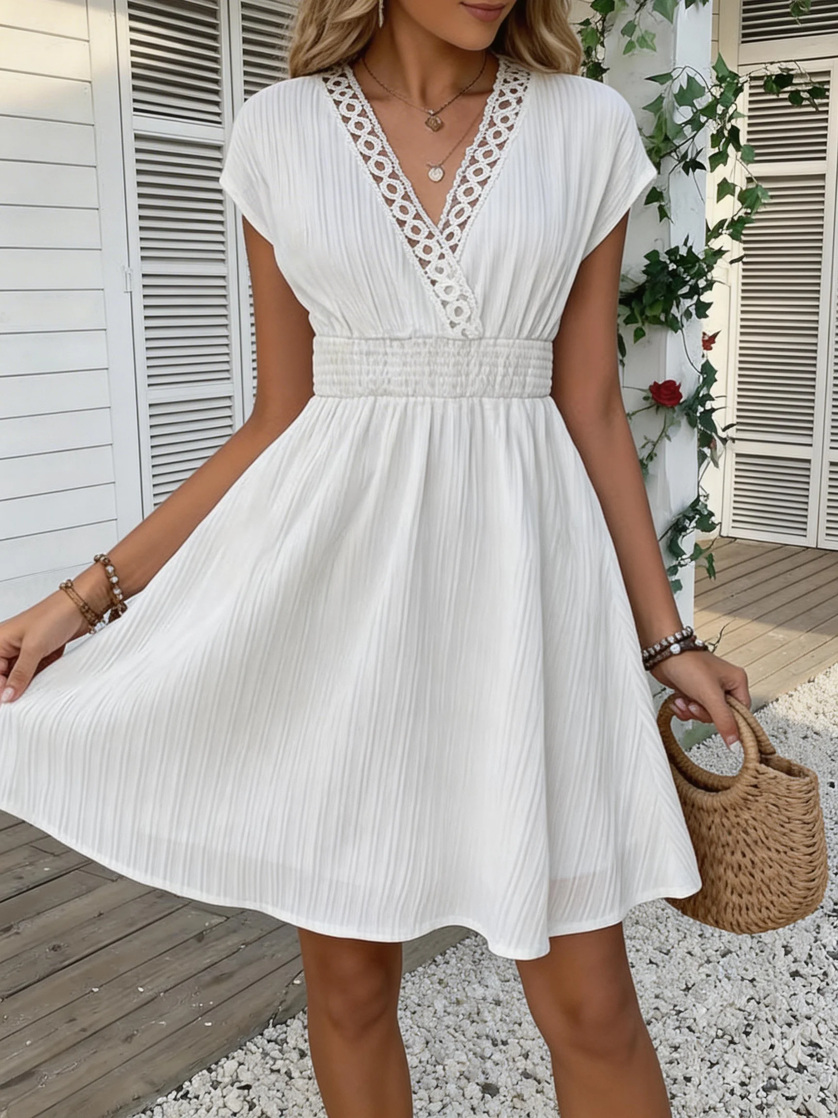 Robe ajustée en dentelle française à col en V avec taille cintrée et manches courtes bouffantes. Jupe courte à texture rayée avec des lignes verticales. Beach-st
