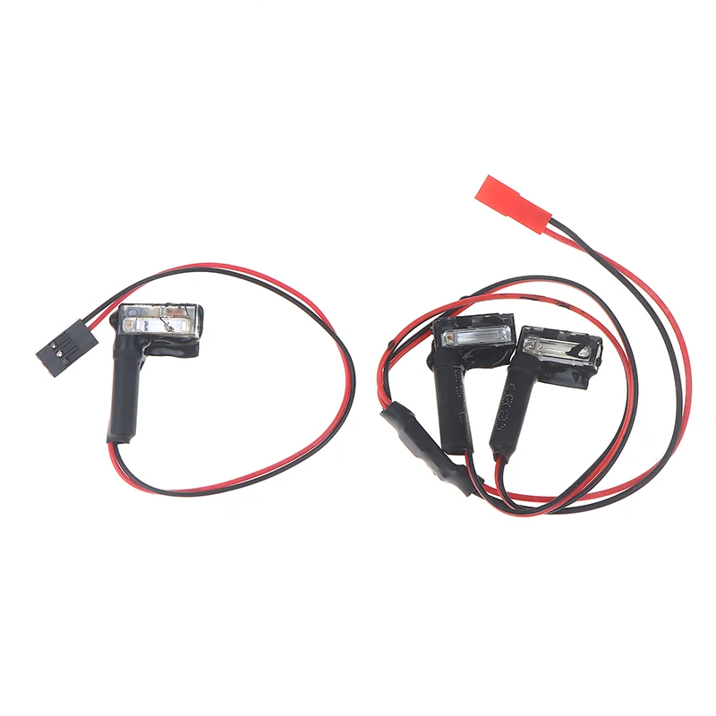 Hélicoptère RC Dual Lights 2.2s posé sur une surface plane, avec son train d'atterrissage et ses lumières allumées.