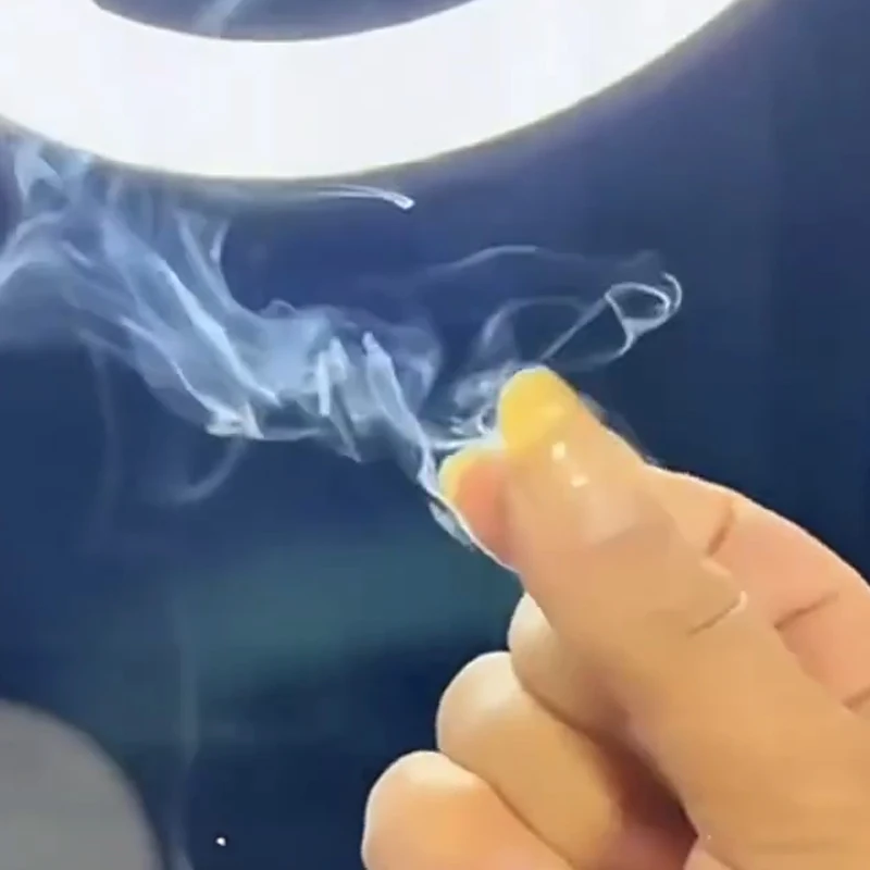Preparing a piece of magic smoke paper on a fingertip before use