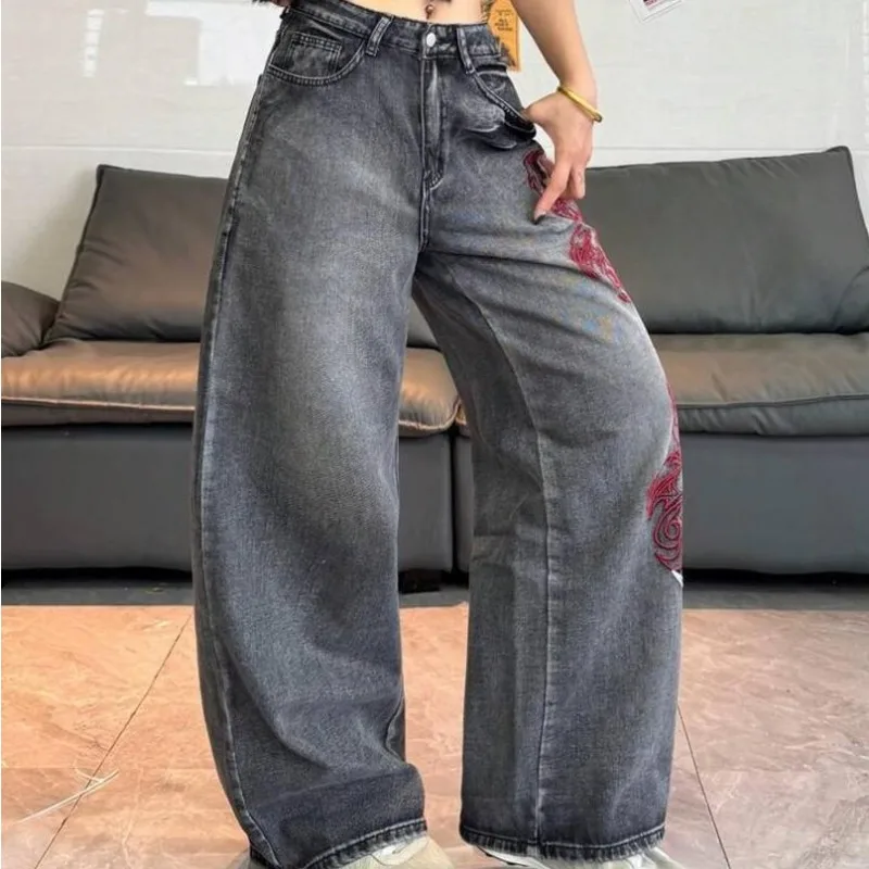 Jean vintage gris foncé délavé pour femme, taille haute, coupe large, avec broderie abstraite rouge et blanche sur le côté, en denim, collection été 2026, style streetwear européen