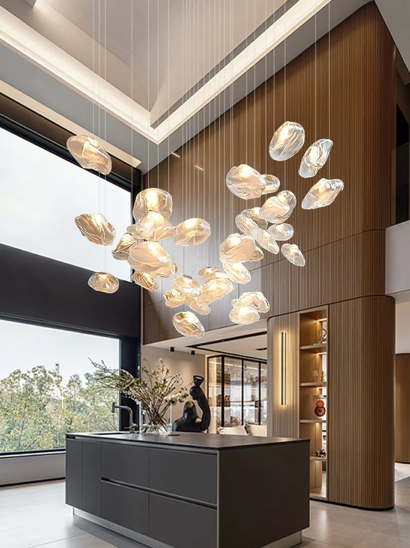 Modern lobby with high ceilings, large windows, a central island, and a Luxe Cloud Glass Pendant Light that creates a striking focal point above the space.