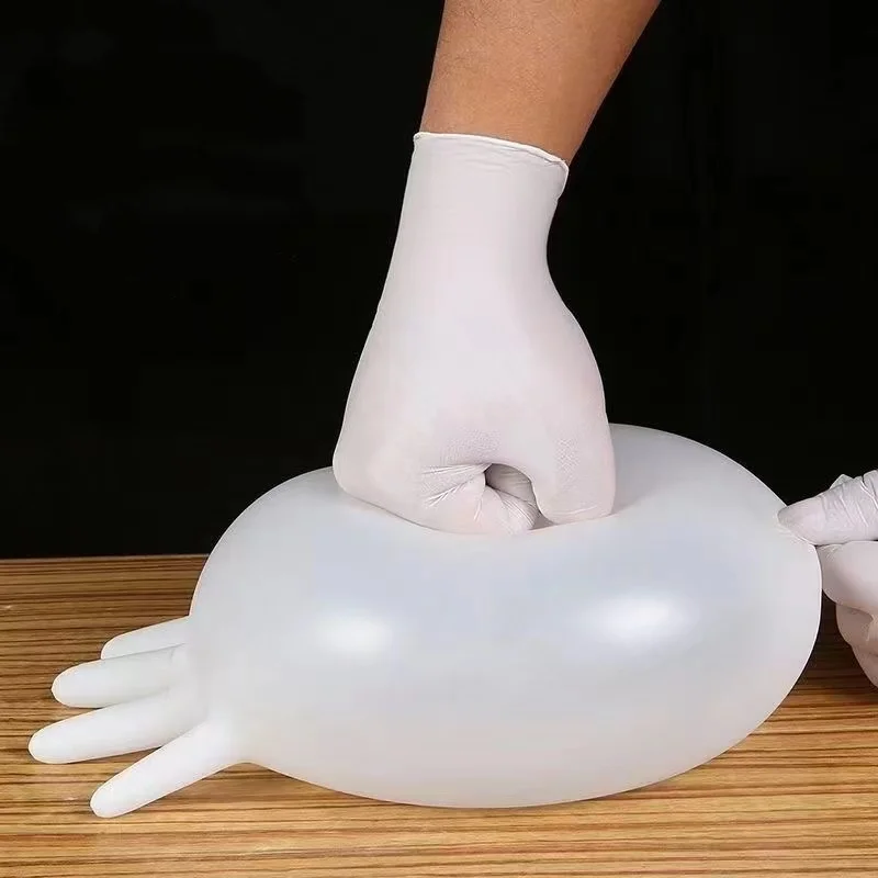 Gants nitrile jetables blancs en taille L, doigts écartés, élastique au poignet.