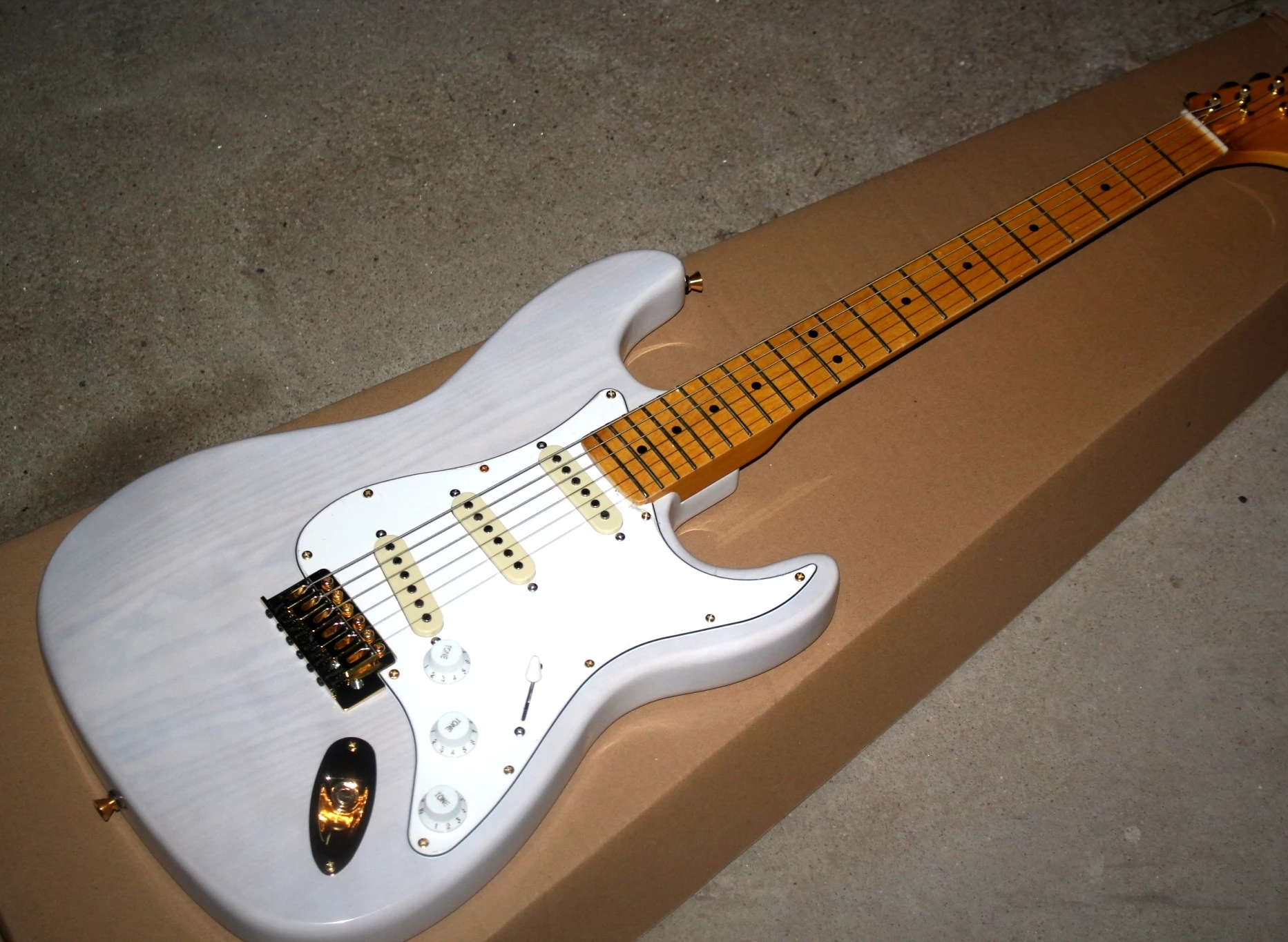 

Made in China high-grade 6-string electric guitar, transparent white, ash wood body, three single pickup, five level tone conver