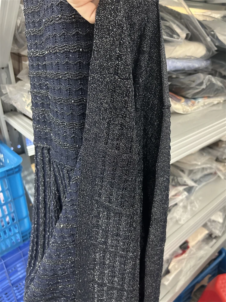 فستان كحلي طويل بتفاصيل لامعة وأكمام واسعة