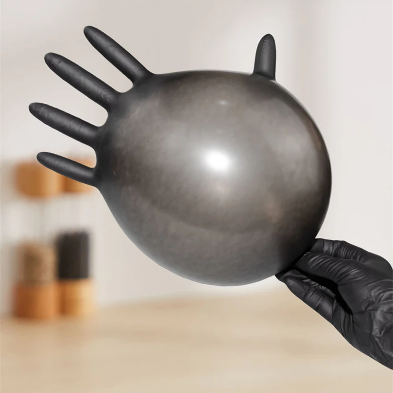 Gants nitrile jetables noirs enroulés montrant leur texture fine et résistante.