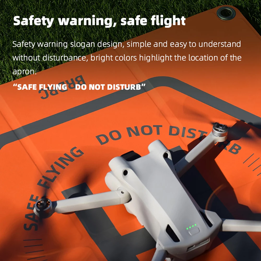 Drone DJI en vol stationnaire au-dessus du tapis d'atterrissage double face, atterrissage précis facilité.